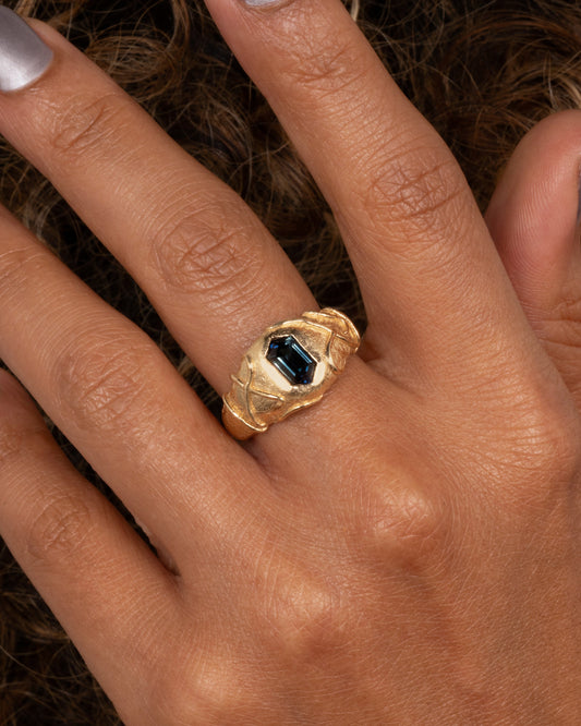 Blue Sapphire Signet Ring — worn on a hand, showing the broad signet profile.