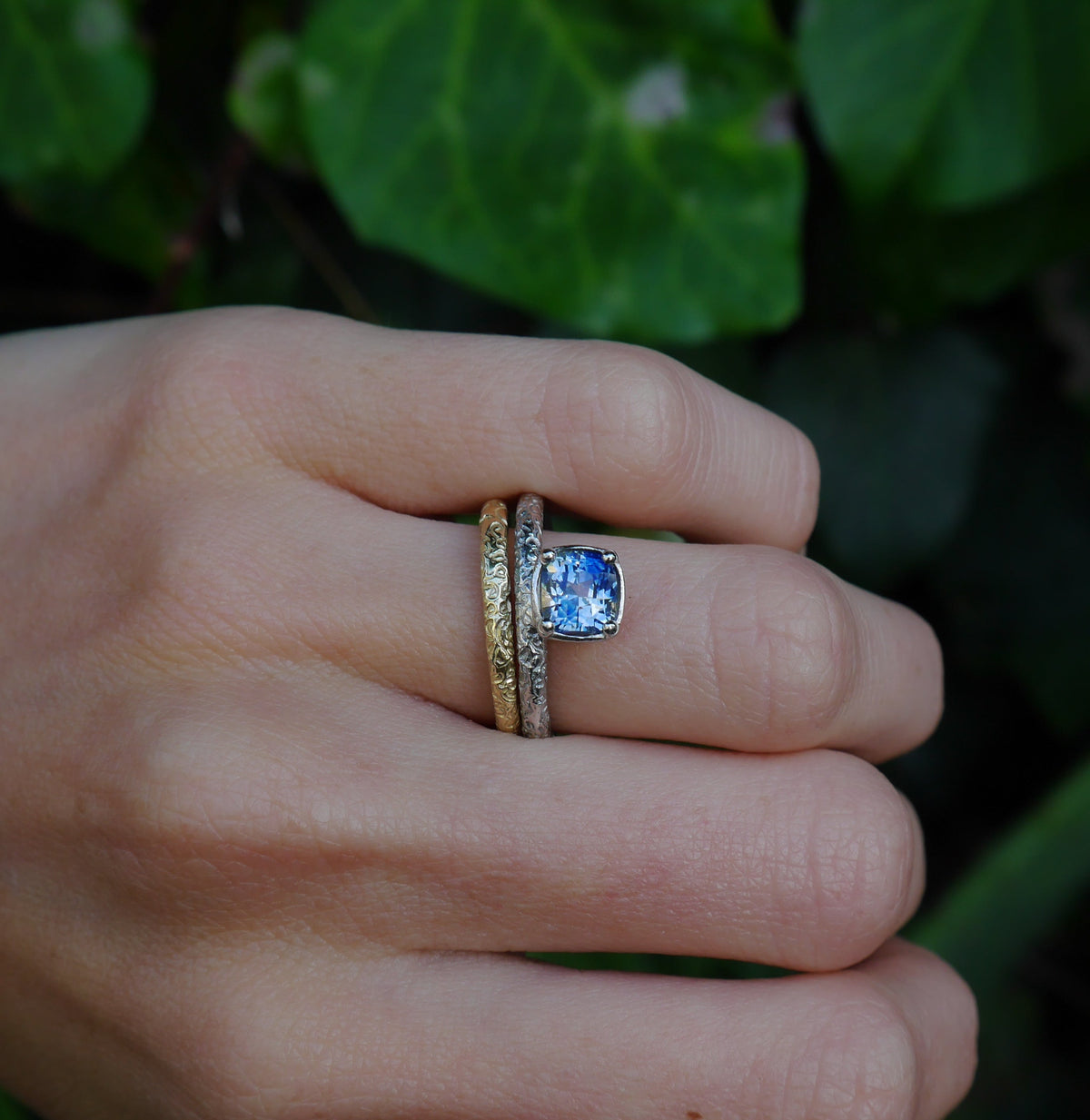 Aurora Ring — worn beside a slim textured band.