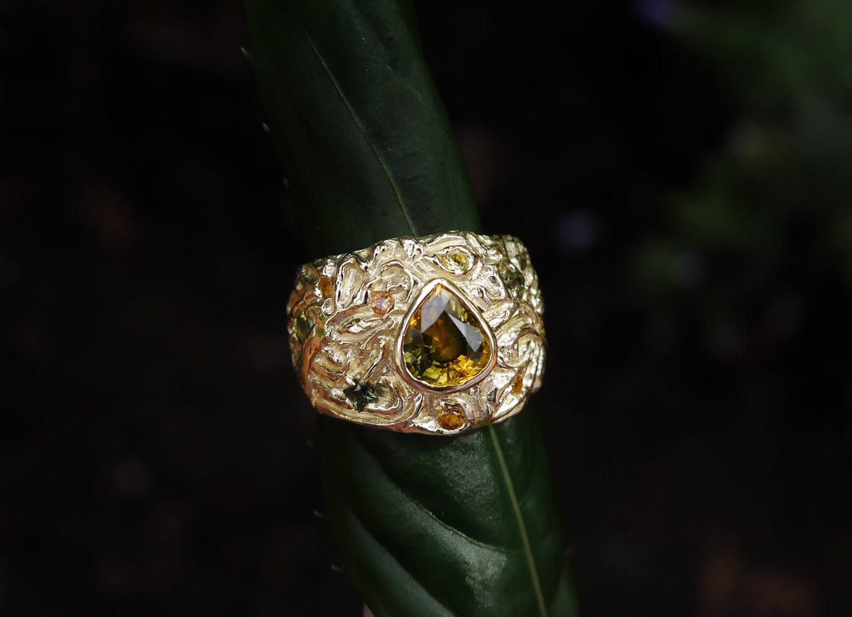The Turning Art Ring — styled upright on a green leaf.