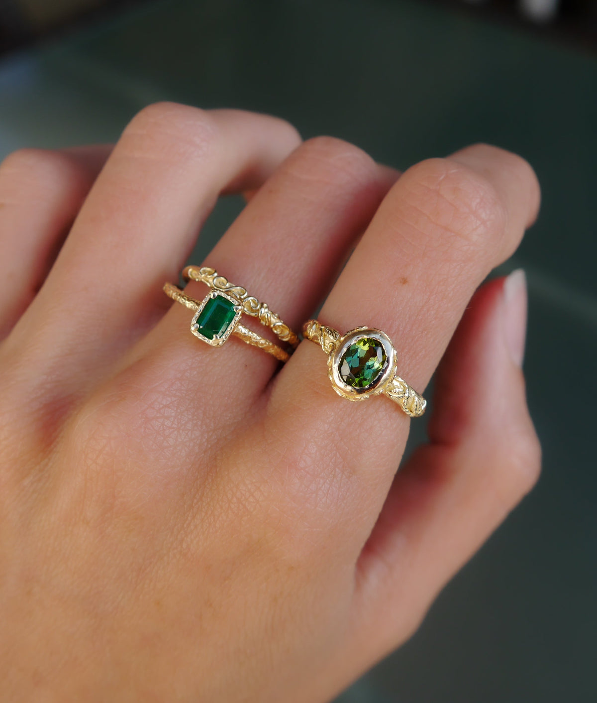 Emerald Script Ring — emerald ring worn beside a second gemstone ring.