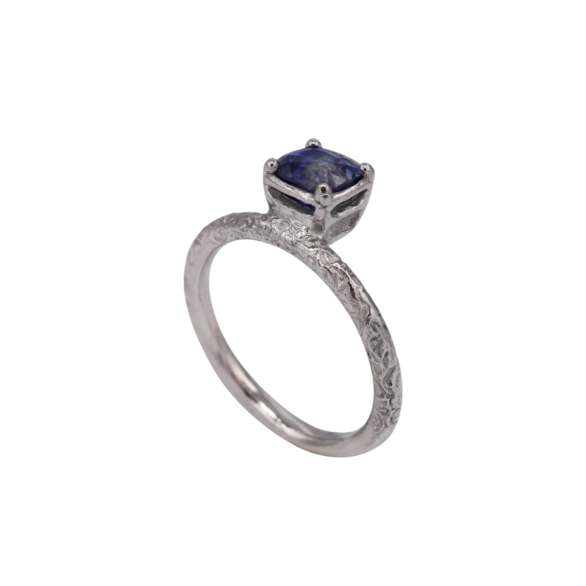 Aurora Ring — side profile showing the raised sapphire setting and scrolling band.
