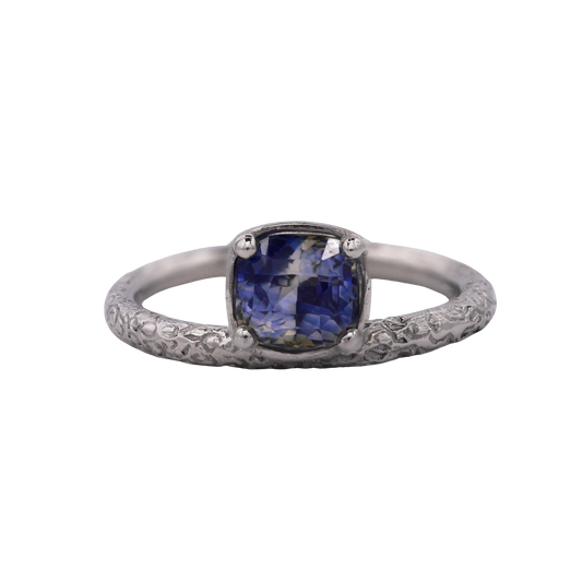 Aurora Ring — front view of a cushion sapphire in a four-prong setting above a scrolling band.