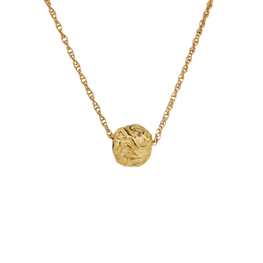 Circular Thoughts — An irregular yellow-gold pendant with raised scrolling relief is integrated into an open organic-link chain.