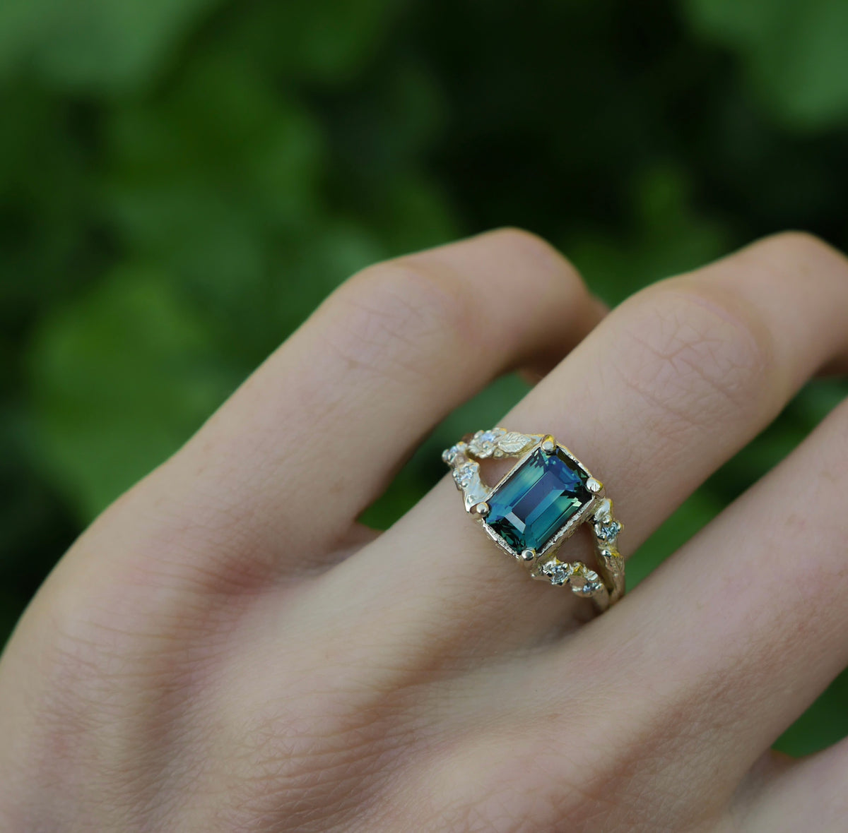 Custom sapphire and diamond ring worn on the hand