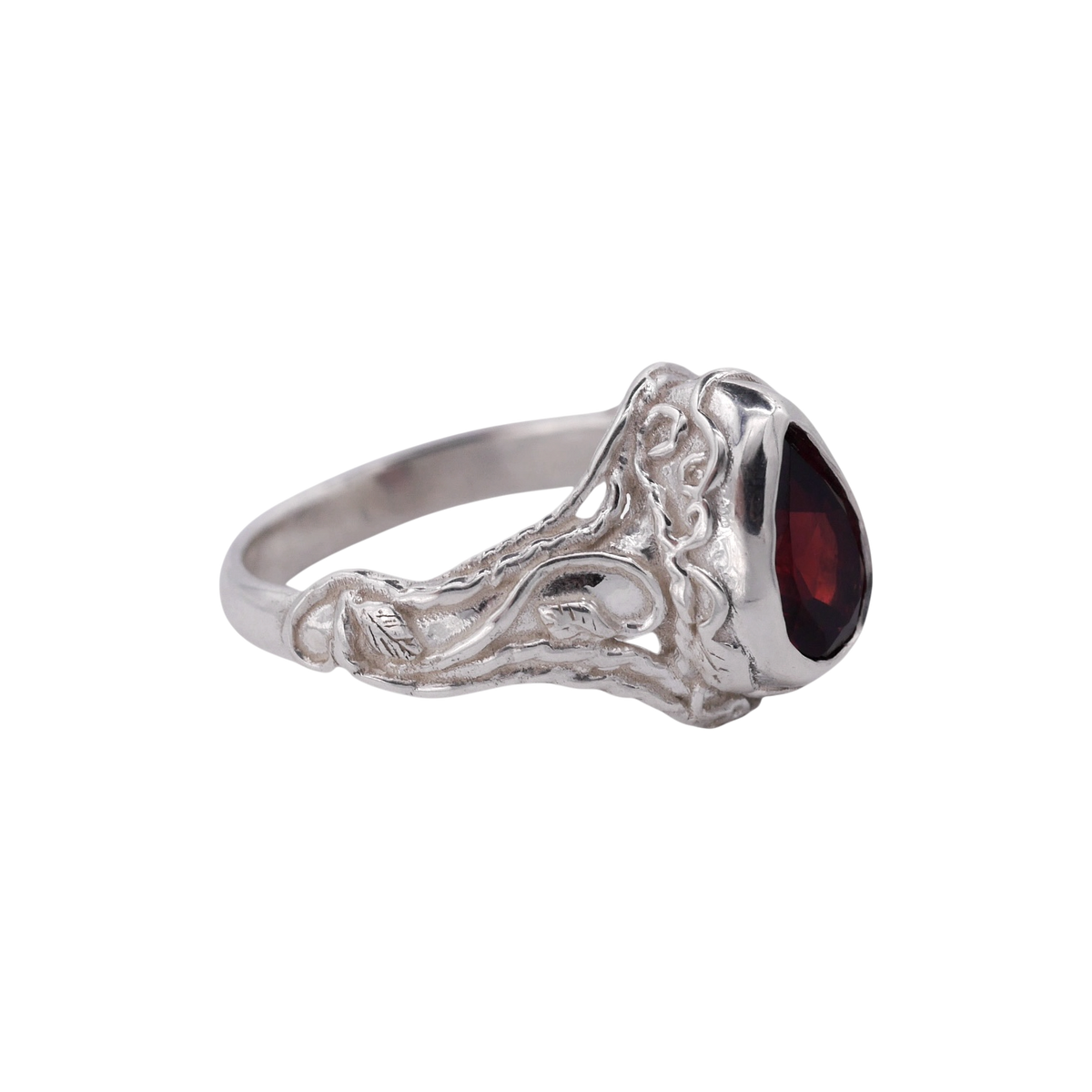 Entangled Ring Silver — three-quarter profile showing the garnet bezel and scrolling silver band.