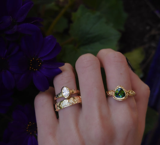Gold Evergreen Ring — worn in a mixed gemstone ring stack outdoors.