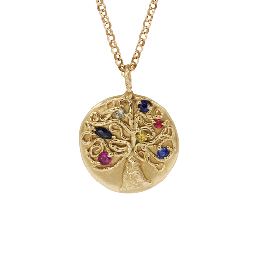 Fruiting Tree Pendant — An oval yellow-gold tree pendant carries seven small sapphires and rubies in blue, yellow, pale, red, and pink tones.