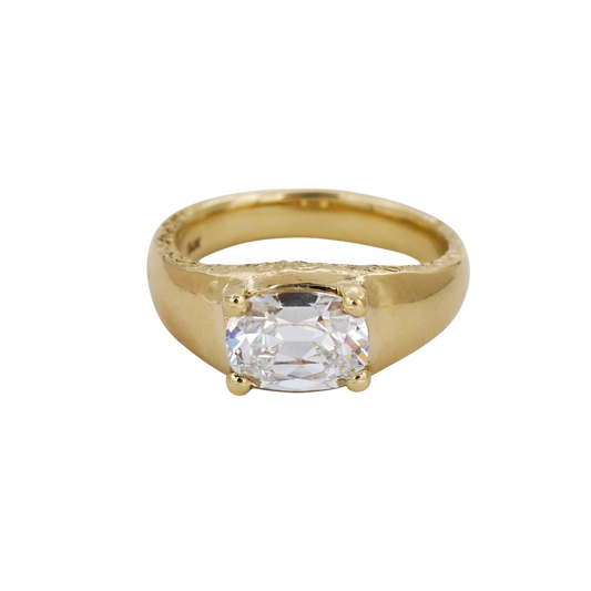 Heirloom Ring — A colorless elongated cushion diamond is held by four rounded prongs above a broad, tapered yellow-gold ring.