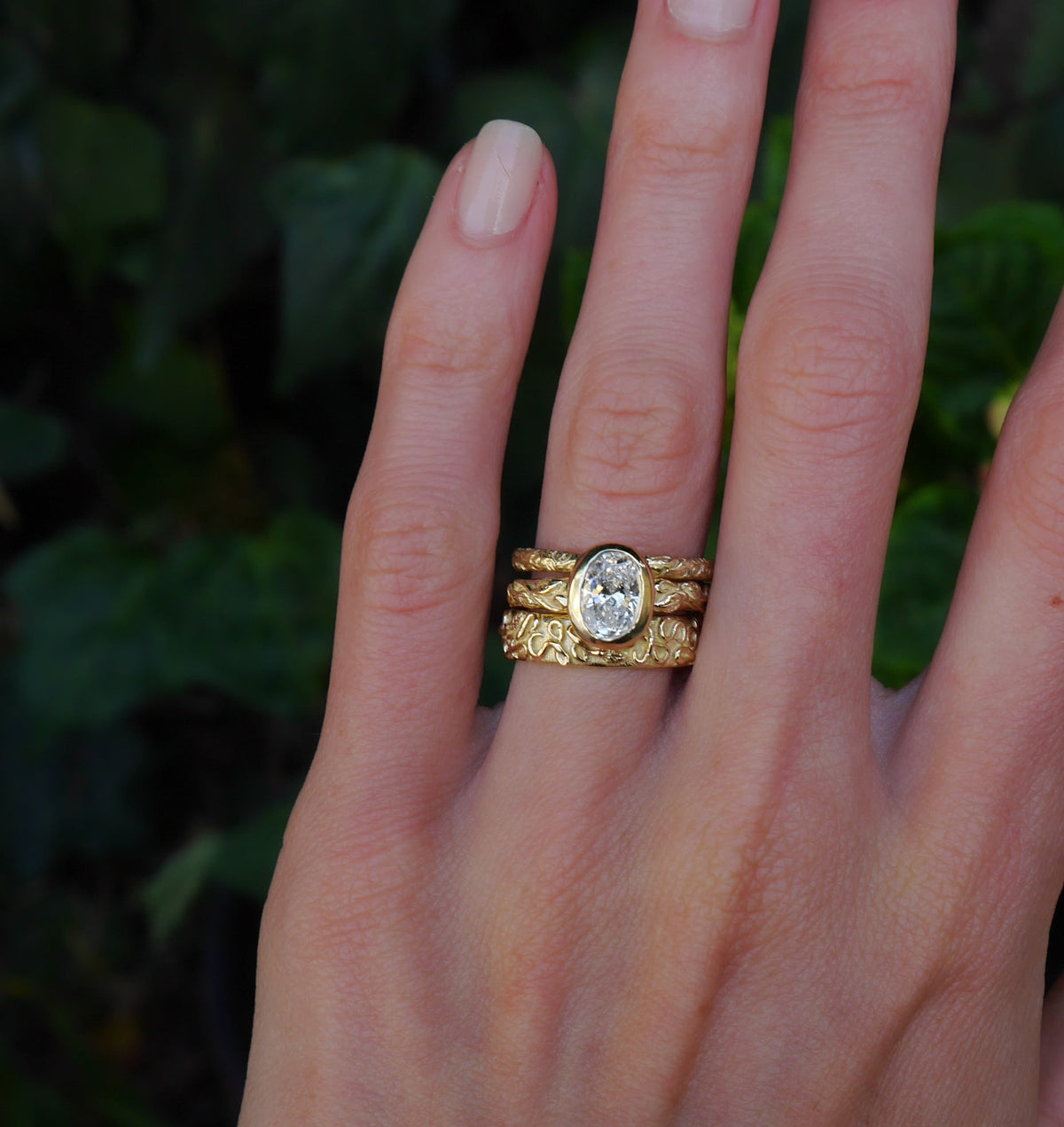Interlaced Diamond Ring — worn between two textured bands.