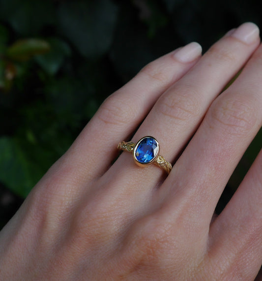Interlaced Ring Sapphire — worn alone on a hand outdoors.