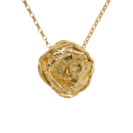 Messenger Pendant Necklace — An irregular yellow-toned medallion with a sculpted human face is suspended from a fine oval-link chain.