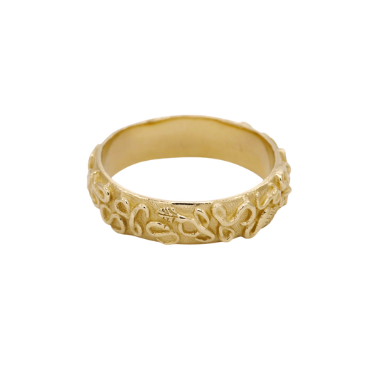 Revelation Band — A broad yellow-gold band is wrapped in raised looping vines, leaves, and scrolling relief over a textured ground.