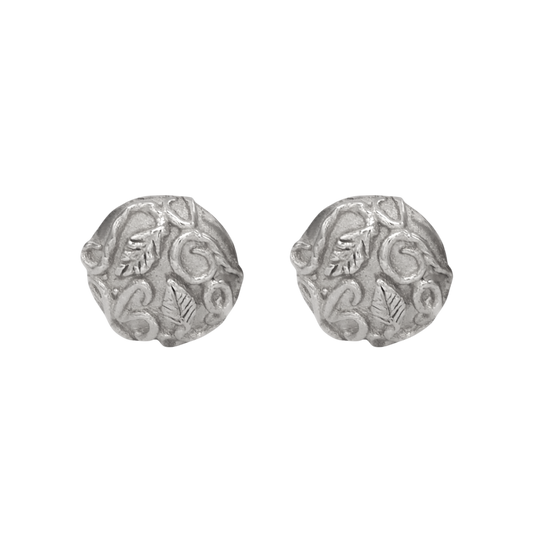 Revelation Stud Earrings Silver — Round sterling-silver studs display raised leaves and scrolling vines across softly irregular textured faces.