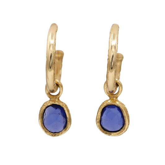 Sapphire Dewdrop Earrings — Two violet-blue irregular sapphires in textured yellow-gold bezels hang beneath smooth hoop tops.
