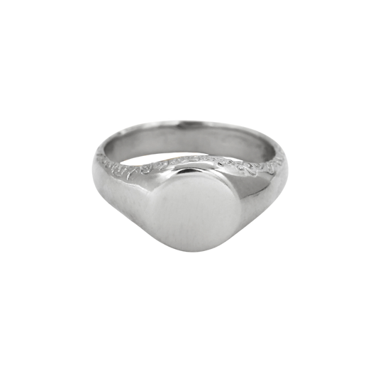 Scribe Signet Ring Silver — A sterling-silver signet ring has a blank rounded face, broad tapered shoulders, and incised scrolling along the upper shank.