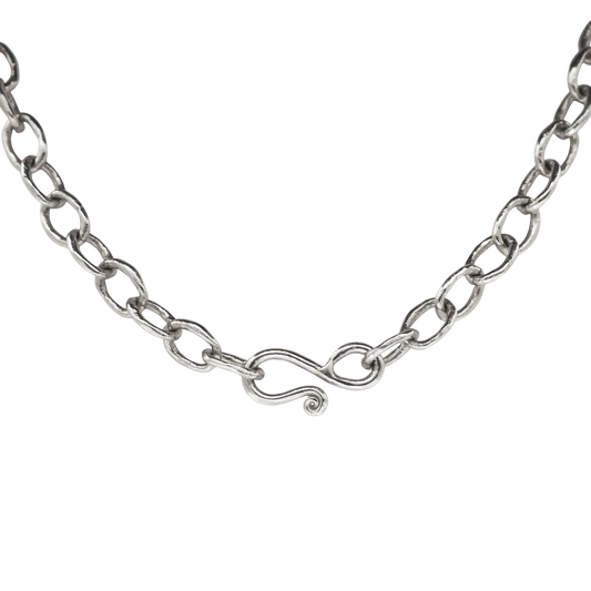 Silver Chain — A sterling-silver necklace is formed from irregular oval links and closes with a sculptural S-hook ending in a small spiral.