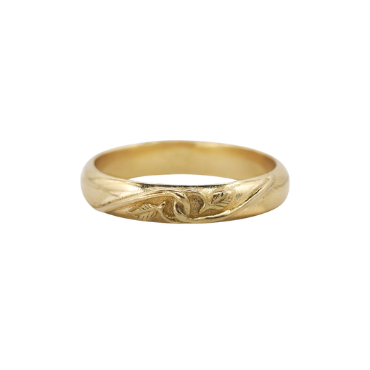 Tethered Ring — A yellow-gold band has a softly domed profile with a recessed vine-and-leaf motif wrapping across its front.