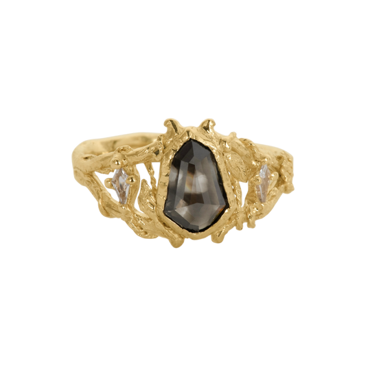 Through The Gates Ring — A shield-cut black diamond is bezel-set between two colorless kite-cut sapphires in an open yellow-gold-colored ring.
